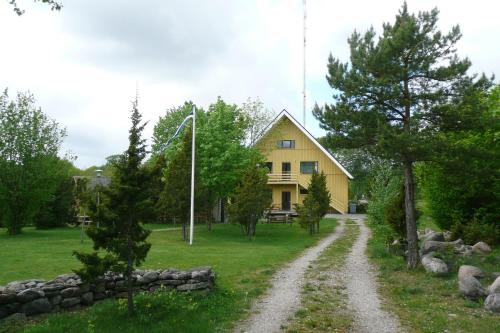 a yellow house with a gravel road in front of it at Pähklimäe Laagrikeskus in Vanamõisa
