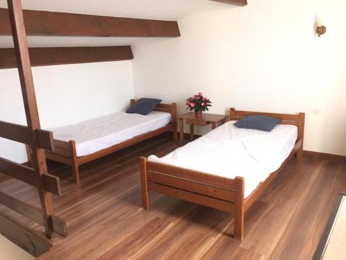 two beds in a room with wooden floors at Alizés in Saint-Denis-dʼOléron