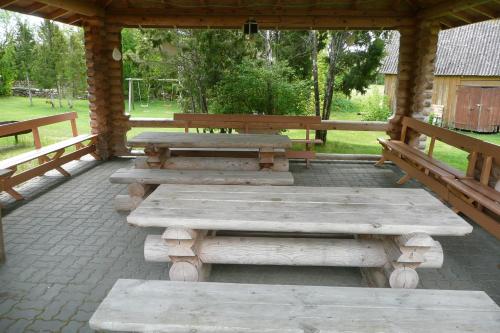a pavilion with wooden tables and benches in a park at Pähklimäe Laagrikeskus in Vanamõisa