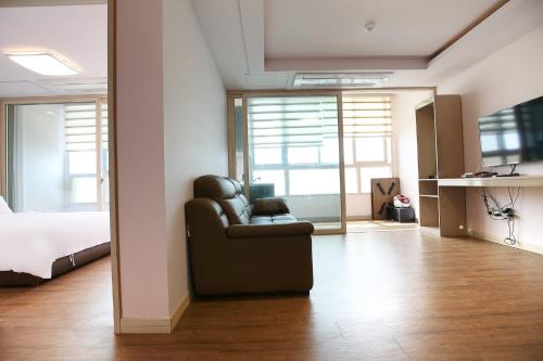 a living room with a chair and a bed at Hotel Lohas in Boryeong