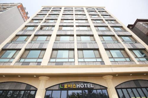 a tall building with a hotel sign on it at Hotel Lohas in Boryeong