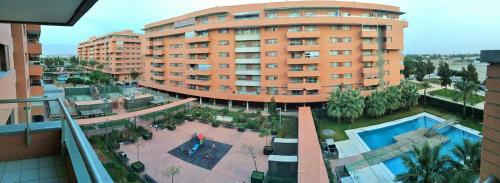 un gran edificio de apartamentos con piscina frente a él en Goleta Almeria en Almería