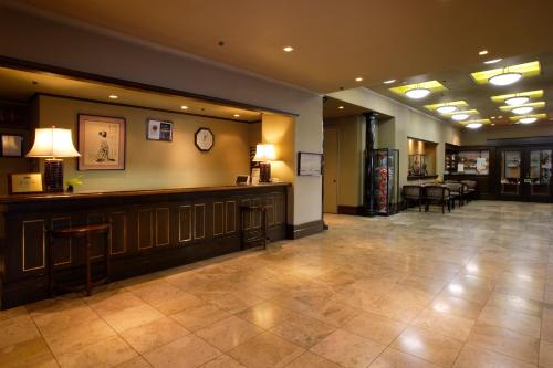 a lobby with a bar with chairs and tables at Kishigon Ryokan in Shibukawa