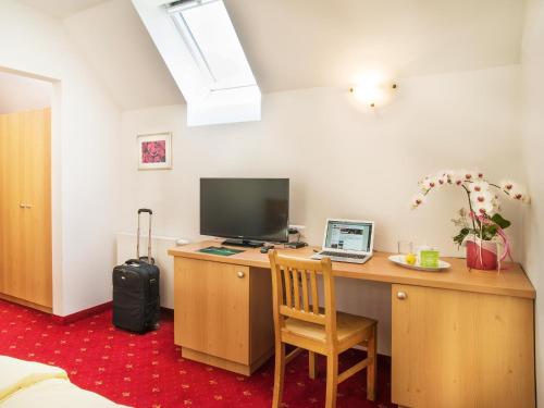 a room with a desk with a computer and a laptop at Landhof Steinbäck in Sankt Stefan ob Stainz