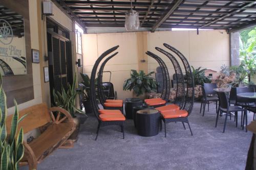a restaurant with chairs and tables and a room with plants at Spring Plaza Hotel in Dasmariñas