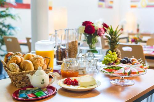 ユーバーリンゲンにあるBed & Breakfast Rotes Hausのパンとフルーツのバスケットをトッピングしたテーブル
