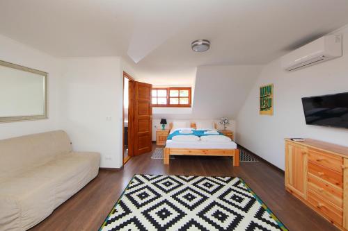 a living room with a bed and a couch at Arácsi Vendégház in Balatonfüred