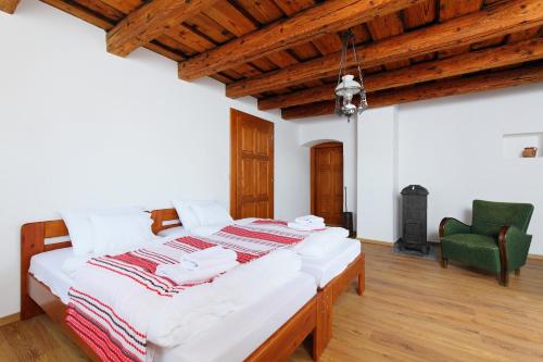 a bedroom with a large white bed with a green chair at Arácsi Vendégház in Balatonfüred