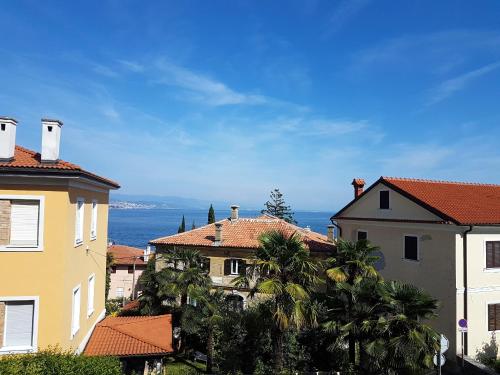a group of buildings with the ocean in the background at Holiday Home Dunja in Opatija