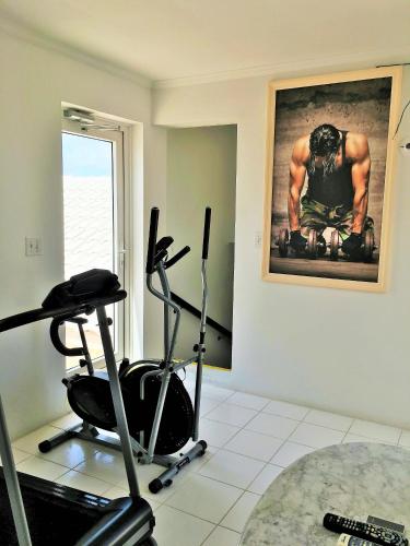 a room with a gym with a treadmill and a picture at Ocean West Boutique Hotel in Nassau