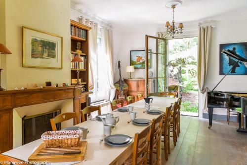 une salle à manger avec une table et des chaises et une cheminée dans l'établissement Villa Ariane, à Saint-Jorioz