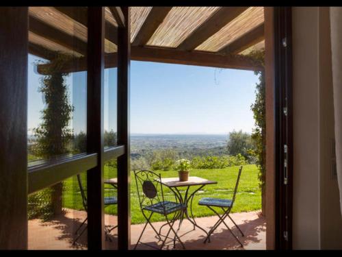 a table and chairs on a patio with a view at Podere Raffanna Ecologic House in Massa e Cozzile