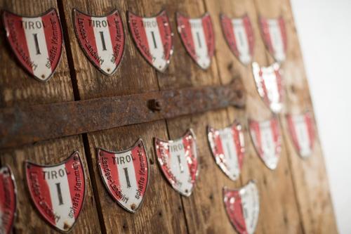 a row of red and white hearts on a wooden wall at Frieden DAS Alpine Panorama Hotel in Pill