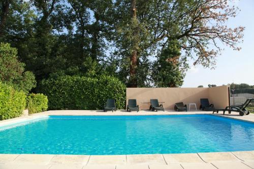 una piscina con sedie e una piscina di Logis Hôtel Restaurant La Borie a Saint-Geniès