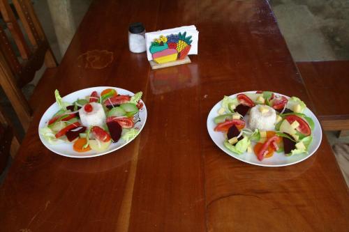 two plates of food on a wooden table at B&B, family run homestay, Hospedaje La Penita in Altagracia