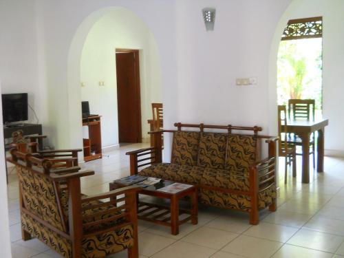 a living room with a couch and chairs and a table at Villa Wunderschön in Bentota