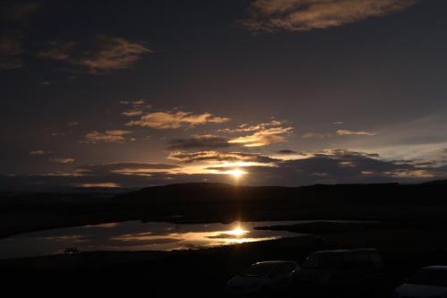 a sunset over a body of water at Hvoll Hostel in Kirkjubæjarklaustur
