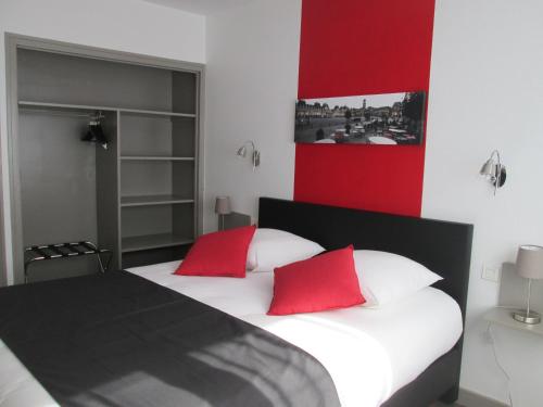a bedroom with two red pillows on a bed at Auberge en Ardenne in Les Hautes-Rivières