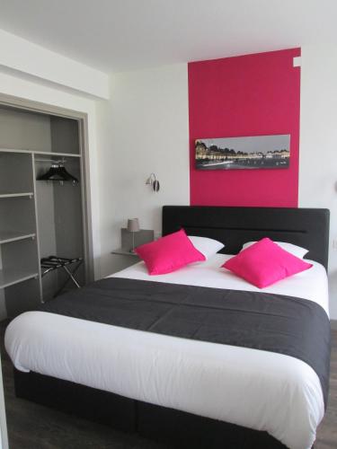 a bedroom with a large bed with pink pillows at Auberge en Ardenne in Les Hautes-Rivières