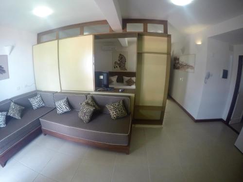 a living room with a couch with pillows on it at Hotel Sao Francisco in Jericoacoara