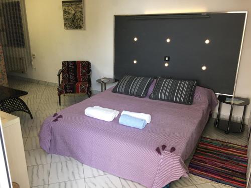 a bedroom with a purple bed with two towels on it at Apartment Eden in Veprinac