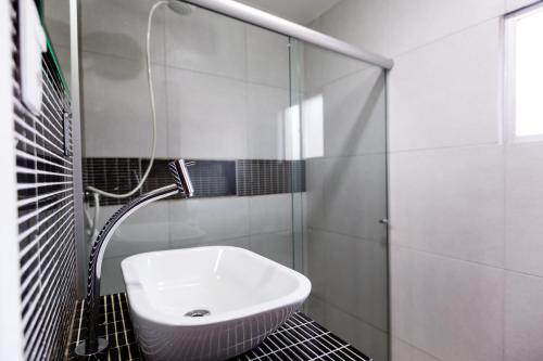uma casa de banho com um lavatório e um chuveiro em Pousada do Mano em Fernando de Noronha