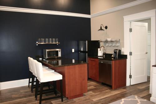 a kitchen with black walls and a counter with white chairs at Anchor Inn Boutique Hotel in Put-in-Bay