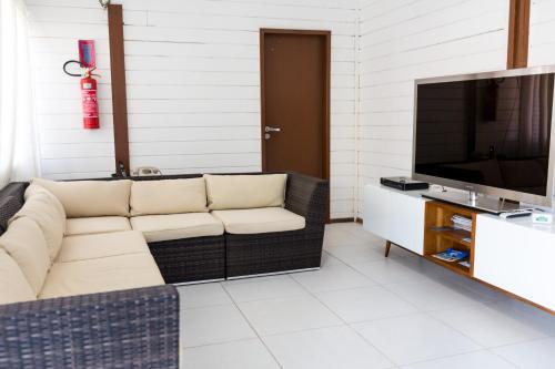 a living room with a couch and a television at Pousada do Mano in Fernando de Noronha