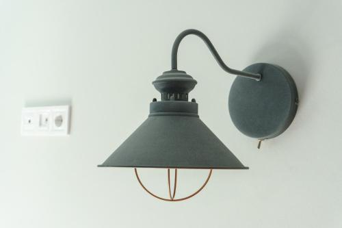a green lamp hanging on a wall with a mirror at Authentic Odessa Dacha in Odesa
