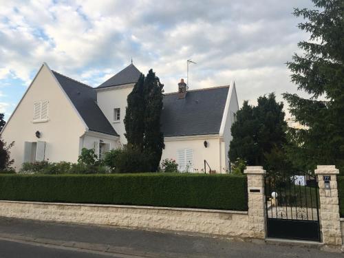 a white house with a black roof and a fence at La Tour de Saint Cyr in Saint-Cyr-sur-Loire