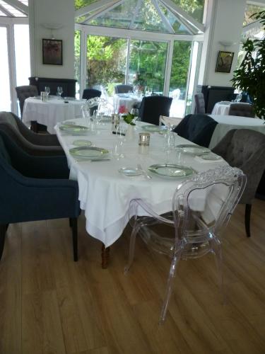 a dining room with a white table and chairs at Hotel Le Rivage in Olivet