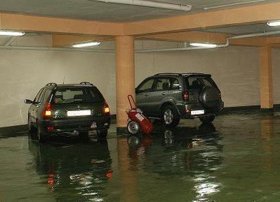 two cars are parked in a flooded garage at Premier Hotel in Skopje