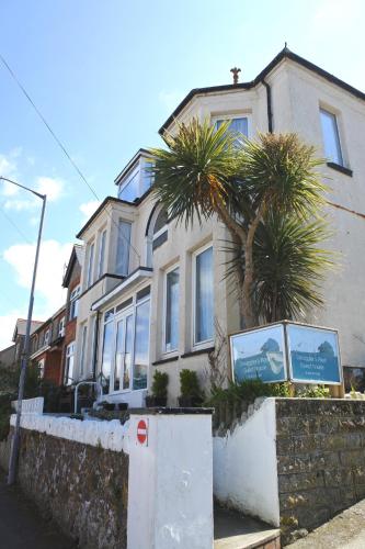 a house with palm trees in front of it at Smugglers Rest in Newquay