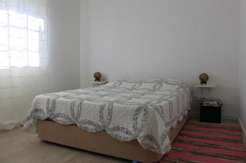 a bedroom with a bed with a blanket on it at Avo das Bolachas nº 12 in Nazaré