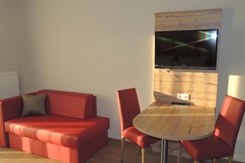 a living room with a couch and a table with a laptop at Hotel-Gasthof Neue Post in Leutershausen