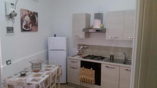 ナポリにあるFlaviogioia Apartmentのキッチン(コンロ、シンク、テーブル付)