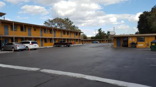 a parking lot in front of a yellow building at Budget Motel in Orlando