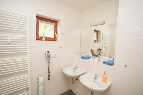 a white bathroom with two sinks and a shower at Chalet Harrachov & Wellness Grotta Spa free in Harrachov