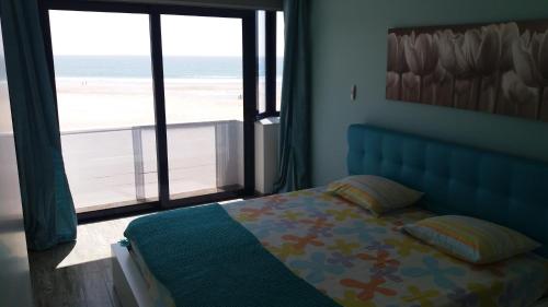 ヴィーラ・プライア・デ・アンコラにあるBlue Anchor Apartmentのビーチの景色を望むベッドルーム1室(ベッド1台付)