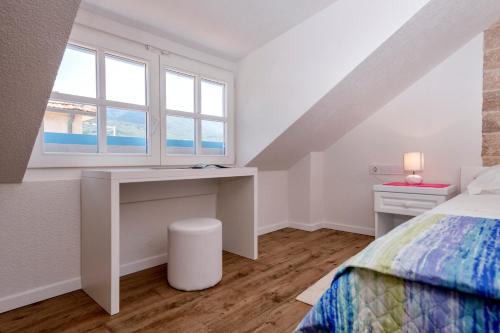 a bedroom with a desk and a bed with a window at Villa Riva in Jelsa