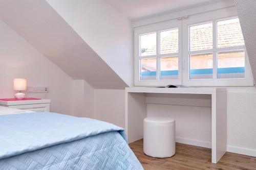 a white bedroom with a bed and a window at Villa Riva in Jelsa