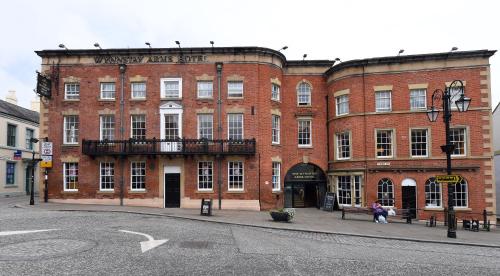 a large red brick building on a city street at Wynnstay Arms, Wrexham by Marston's Inns in Wrexham