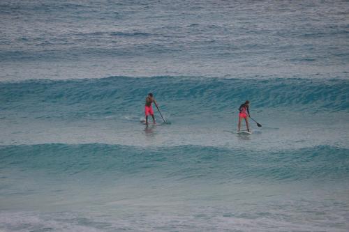 two girls are paddle boarding in the ocean at Ocean View Condo in Cancún