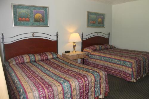 una habitación de hotel con 2 camas y una lámpara en Golden Chain Motel, en Grass Valley