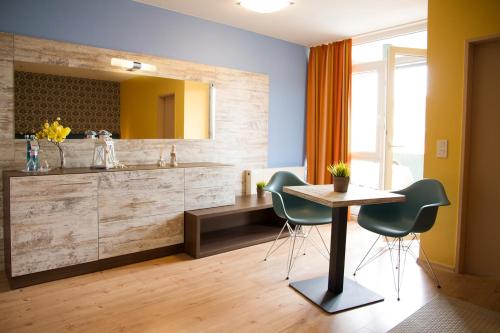 Hotel Harlesiel في هارليسييل: حمام مع مغسلة وطاولة وكراسي