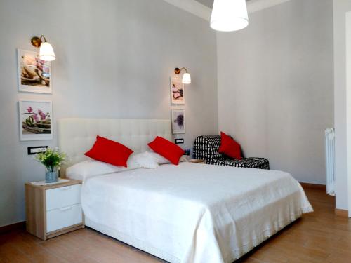 a bedroom with a white bed with red pillows and a chair at Apartment Nice Venice in Mestre