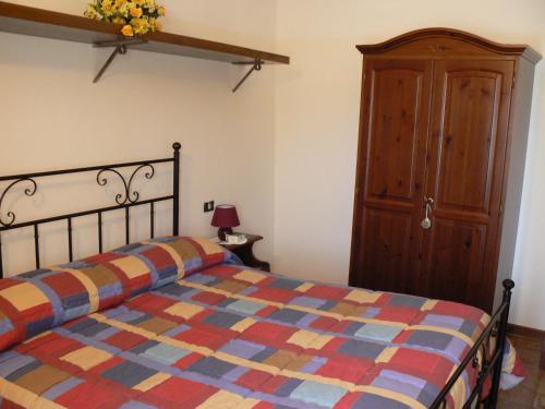 una camera con letto e armadio in legno di Residence Il Palazzo a Santo Stefano di Sessanio
