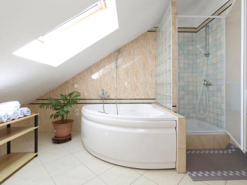 a bathroom with a white tub and a shower at Apartments & Rooms Nikolić in Fažana