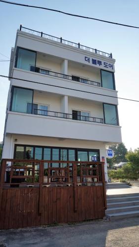 a building with a wooden fence in front of it at Blue Door Hostel Guesthouse in Sokcho