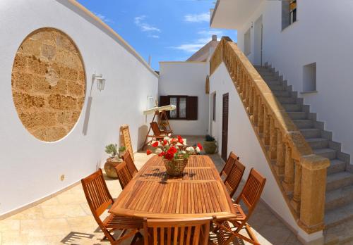 a wooden table and chairs on a patio with stairs at B&B Anemos in Morciano di Leuca